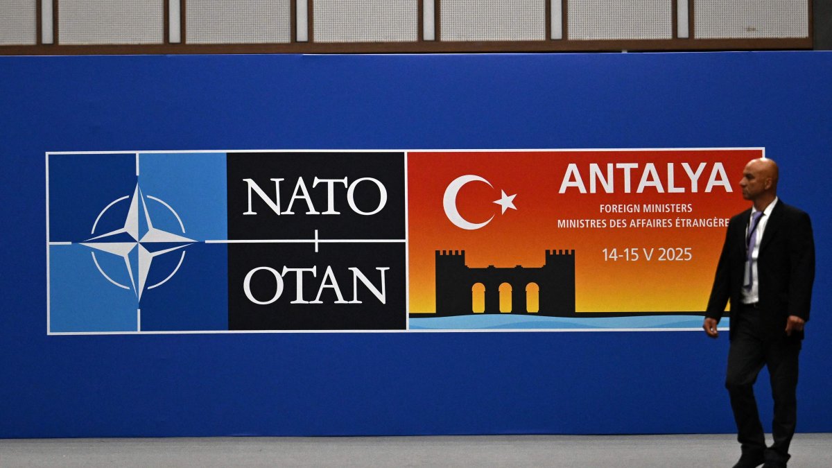 A visitor walks past a board announcing the informal meeting of NATO Ministers of Foreign Affairs, Antalya, Türkiye, May 14, 2025. (AFP Photo)
