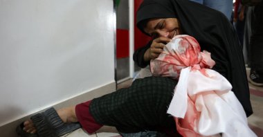 A Palestinian woman cries as she holds the body of a child killed in Israeli strikes on Jabalia, northern Gaza Strip, Palestine, May 14, 2025. (AFP Photo)