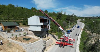 A crane moves a three-story steel structure during the demolition of an illegal villa in Inegöl, Bursa, Türkiye, May 13, 2025. (IHA Photo)