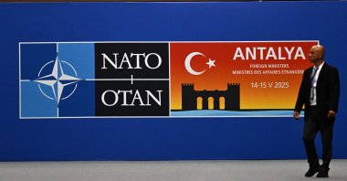 A visitor walks past a board announcing the informal meeting of NATO Ministers of Foreign Affairs, Antalya, Türkiye, May 14, 2025. (AFP Photo)