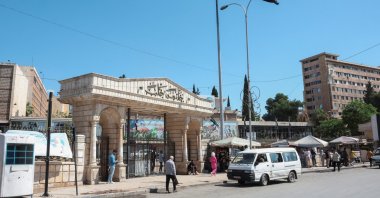 People walk near the Syrian flag, as U.S. President Donald Trump announced that he would order the lifting of sanctions on Syria, in Aleppo, Syria May 14, 2025. (Reuters Photo)