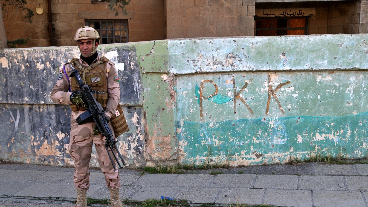 An Iraqi soldier stands next to graffiti of the PKK terrorist group, Sinjar, Iraq, Dec. 4, 2020. (AP Photo)