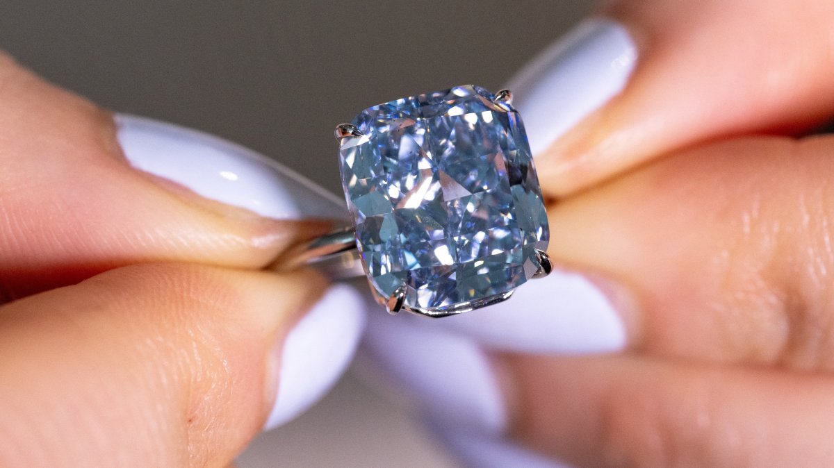 A Sotheby’s staff member holds &quot;The Mediterranean Blue,&quot; a fancy vivid blue diamond weighing 10.03 carats, estimated to reach 20 million Swiss francs during an auction preview, Geneva, Switzerland, May 8, 2025. (Reuters Photo)