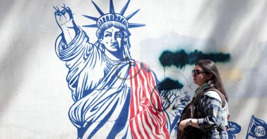 A woman walks next to an anti-U.S. mural near the former U.S. embassy in Tehran, Iran, May 11, 2025. (AFP Photo)