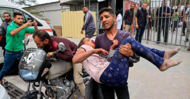 A Palestinian man carries a wounded person to Nasser hospital following an Israeli strike, in Khan Younis, southern Gaza Strip, Palestine, May 15, 2025. (Reuters Photo)