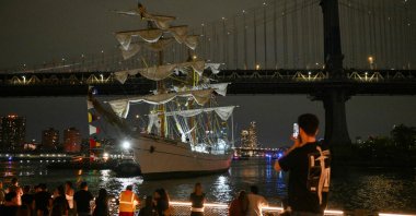 People watch as a Mexican Navy training ship is pulled away after it slammed into the nearby Brooklyn Bridge in New York, U.S., May 17, 2025. (AFP Photo)