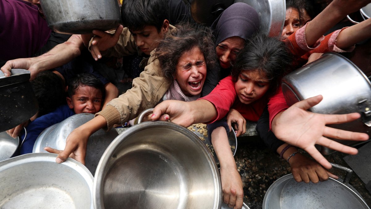 Palestinians wait to receive food cooked by a charity kitchen in Jabalia, in the northern Gaza Strip, May 14, 2025. (Reuters Photo)