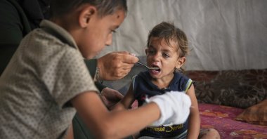 A little boy is fed by his mother with food from a community kitchen at the al-Muwasi camp for displaced Palestinians in Khan Younis, southern Gaza Strip, Palestine, May 18, 2025. (AP Photo)