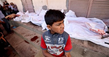 A boy gestures as he stands near the bodies of Palestinians killed in Israeli strikes, in Deir el-Balah, central Gaza Strip, Palestine, May 20, 2025. (AFP Photo)
