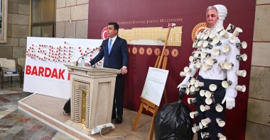 Lawmaker Osman Gökçek speaks at a news conference next to a mannequin and a sign made of paper cups, Ankara, Türkiye, May 8, 2025. (AA Photo)