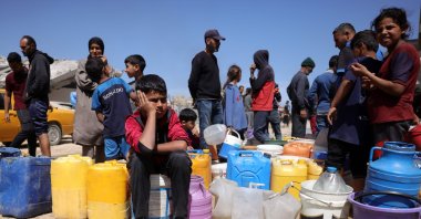  Palestinians attempt to collect water at a camp for displaced people in Gaza City, May 20, 2025. (AFP Photo)
