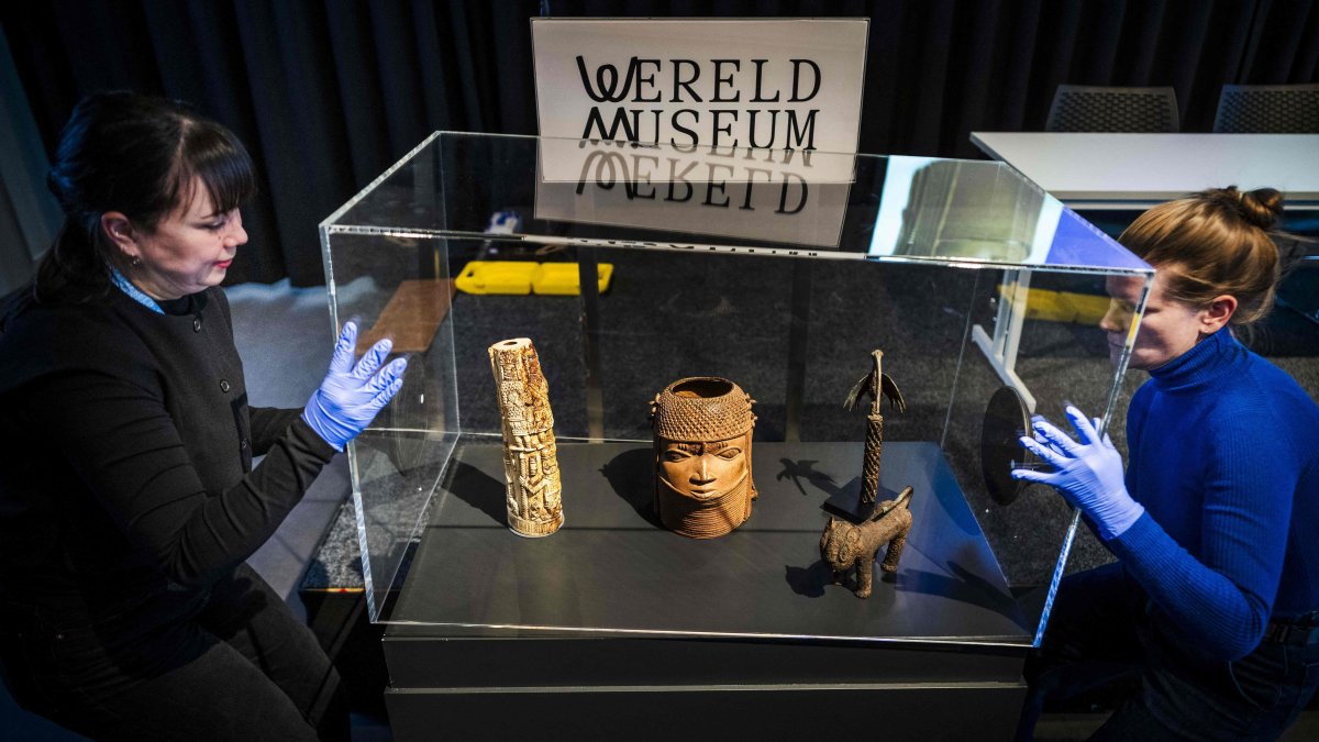 Employees open a glass case containing some of the 113 Benin Bronzes that are being returned to Nigeria, during a handing over ceremony at the Wereldmuseum (World Museum), Leiden, Netherlands, Feb. 19, 2025. (AFP Photo)