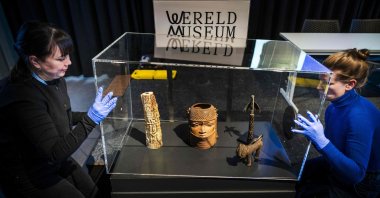 Employees open a glass case containing some of the 113 Benin Bronzes that are being returned to Nigeria, during a handing over ceremony at the Wereldmuseum (World Museum), Leiden, Netherlands, Feb. 19, 2025. (AFP Photo)