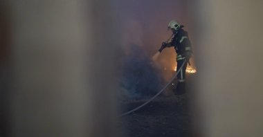 A Ukrainian emergency worker puts out a fire at the site of a Russian missile strike in Sumy, Ukraine, May 21, 2025. (AA Photo) 