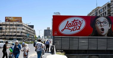 People walk past an advertisement, Damascus, Syria, May 20, 2025. (AFP Photo)