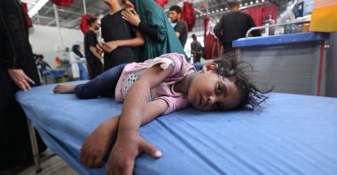 A woman and a child cry as a little girl lies on a hospital bed waiting for first aid treatment at Al-Awda Hospital at the Nuseirat refugee camp in the central Gaza Strip, following an Israeli airstrike that hit a school hosting Palestinian refugees in the camp, May 19, 2025. (AFP Photo)