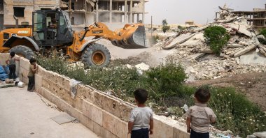 Children watch as a Syrian Civil Defense (White Helmets) tractor removes rubble outside the city of Maarat al-Numan, in the southern Idlib countryside, Syria, May 12, 2025. (EPA Photo)