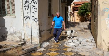 A man and his dog walk past debris, following an earthquake that hit the island of Crete, in Heraklion, Greece, May 22, 2025. (Reuters Photo)