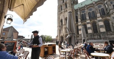 Customers drink on a terrace of a cafe in front of Chartres Cathedral, Chartres, France, May 7, 2025. (AFP Photo)