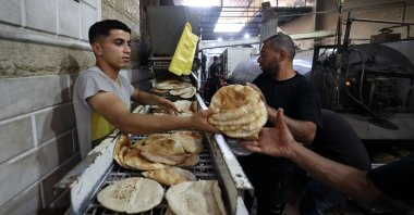 Employees of a bakery in Deir al-Balah stack freshly-baked bread after Israel allowed limited humanitarian aid to enter Gaza, Palestine, May 22, 2025. (AFP Photo) 