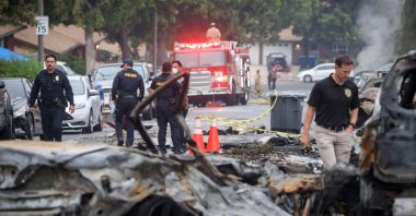 Investigators look through the site where a small plane crashed into San Diego, California, residential street May 22, 2025. (AFP Photo)
