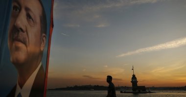 Backdropped by the Bosporus separating Asia and Europe, a man enjoys a stroll as he walks past an election poster of President Recep Tayyip Erdoğan, Istanbul, Türkiye, June 21, 2018. (AP Photo)