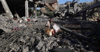  A Palestinian man carries items he salvaged from a house targeted in an Israeli strike at the Nuseirat camp for refugees, Gaza Strip, Palestine, May 24, 2025. (AFP Photo)