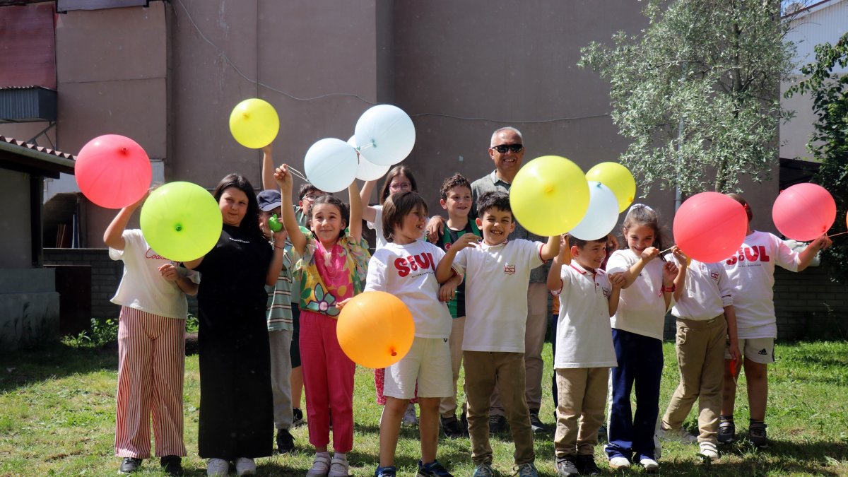 Children enjoy a festive moment with colorful balloons alongside school bus driver Salih Öztaş and his wife during their year-end garden celebration, Sakarya, Türkiye, May 25, 2025. (IHA Photo)