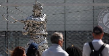 Tennis fans look at the statue of former Spanish tennis player Rafael Nadal, made by Spanish artist Jordi Diez Fernandez, on day 1 of the French Open tennis tournament at the Roland-Garros Complex, Paris, France, May 25, 2025. (AFP Photo)