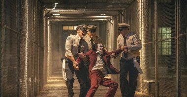 Joaquin Phoenix (foreground C) and Brendan Gleeson (background C) in a scene from &quot;Joker: Folie a Deux.&quot; (AP Photo)