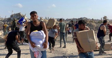 Men look around on alert in the wake of gunfire shots as displaced Palestinians receive food packages from a.S.-backed foundation pledging to distribute humanitarian aid in western Rafah in the southern Gaza Strip, May 27, 2025. (AFP Photo)