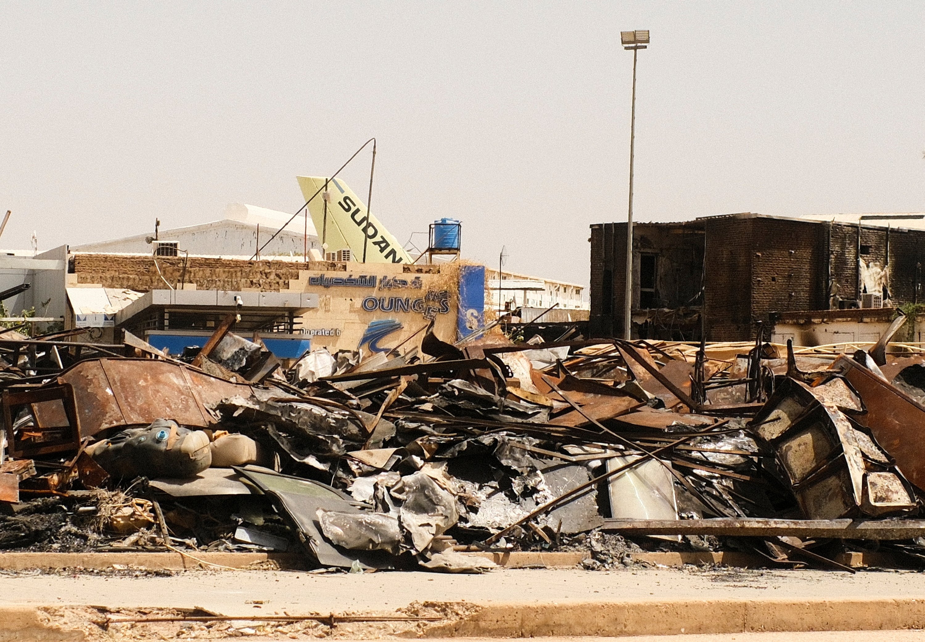 Khartum Havaalanı, Khartum, Sudan, 26 Nisan 2025'te enkazın ortasında yanmış bir binanın ve bir Sudan Airways uçağının kuyruğunun manzarası. (Reuters fotoğrafı)