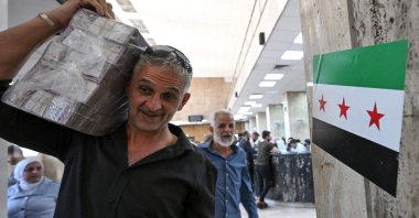 A man carrying a stash of Syrian pounds, leaves the central bank, Damascus, Syria, May 21, 2025. (AFP Photo)