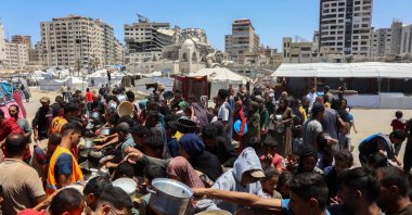 Palestinians line up to receive a hot meal at a food distribution point in the Al-Rimal neighborhood in Gaza City in the central Gaza Strip, May 21, 2025. (AFP File Photo)