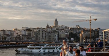 People on a ferry cross the Golden Horn backdropped by the Galata Tower during sunset, Istanbul, Türkiye, May 28, 2025. (EPA Photo)