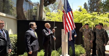 Syrian Foreign Minister Assaad al-Shibani (2nd L) looks on as U.S. special envoy for Syria Thomas Barrack raises the flag of the United States at the U.S. ambassador&#039;s residence in Damascus, Syria, May 29, 2025. (AFP Photo)