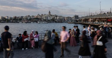People walk near the Golden Horn, backdropped by Galata Tower during sunset, Istanbul, Türkiye, May 28, 2025. (EPA Photo)