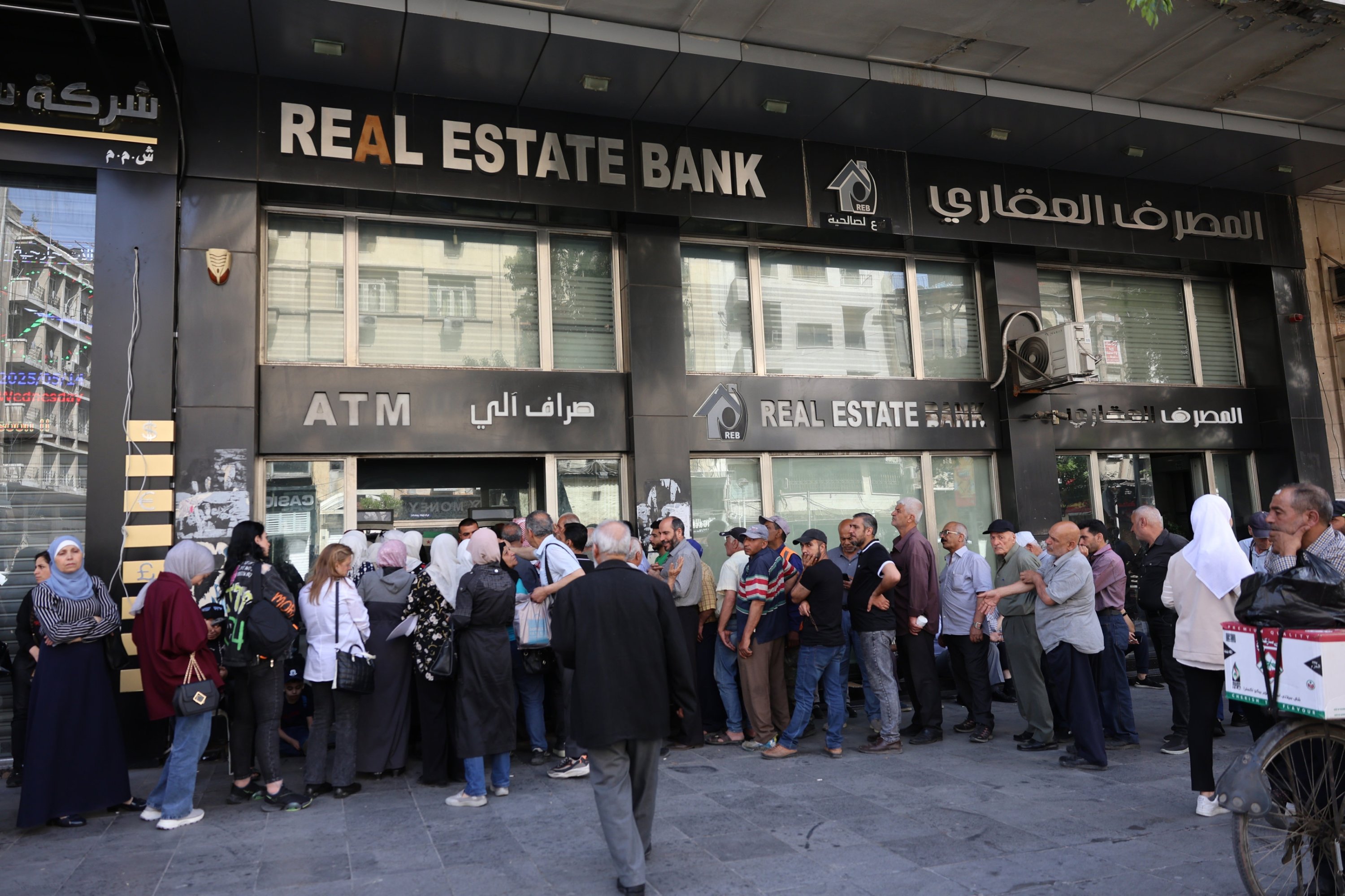People line up outside a bank to exchange dollars for Syrian pounds in the capital Damascus, Syria, May 14, 2025. (EPA Photo)