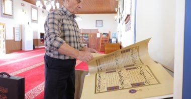 Kasem Hafizi, the mosque&#039;s 78-year-old imam, shows the preserved Quran at the mosque, Tirana, Albania, May 31, 2025. (AA Photo)