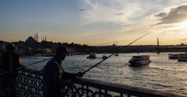 People fish on the Galata Bridge backdropped by the Suleymaniye Mosque during sunset, Istanbul, Türkiye, May 28, 2025. (EPA Photo)