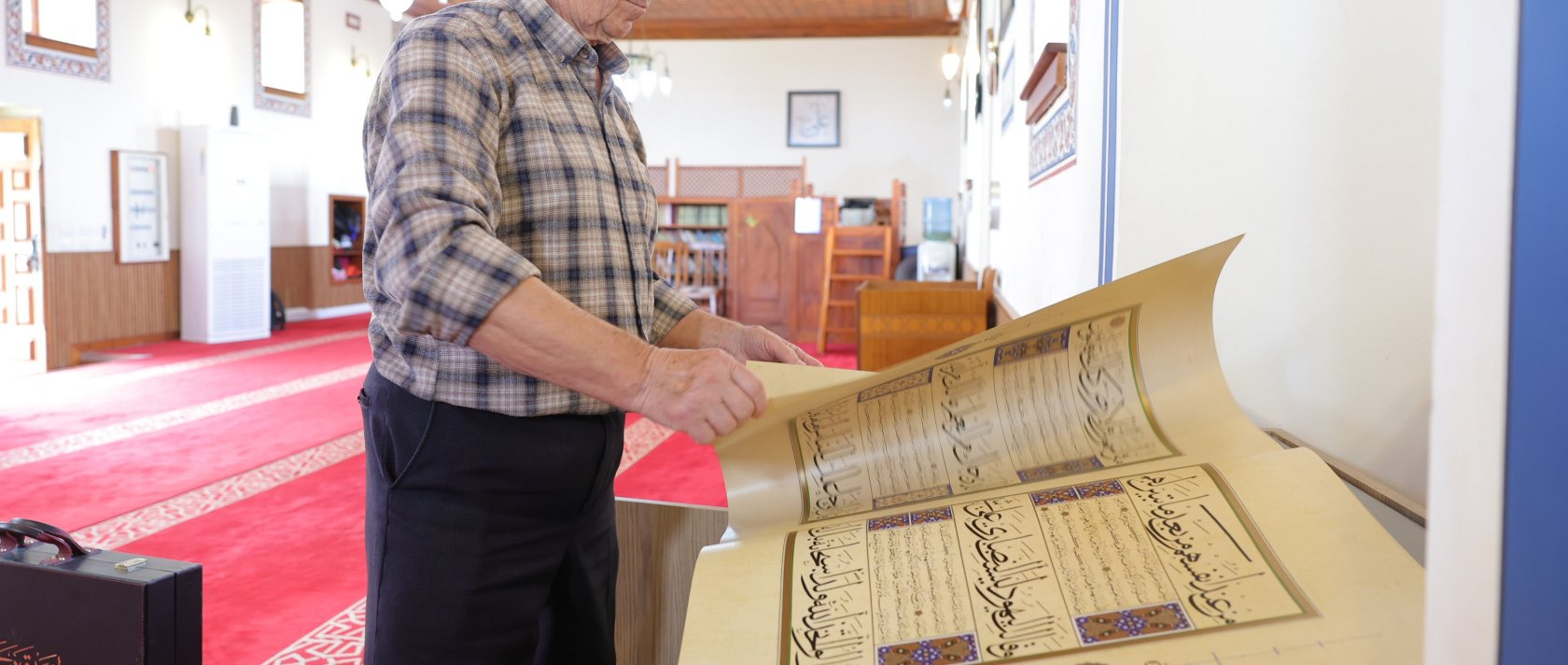 Kasem Hafizi, the mosque&#039;s 78-year-old imam, shows the preserved Quran at the mosque, Tirana, Albania, May 31, 2025. (AA Photo)