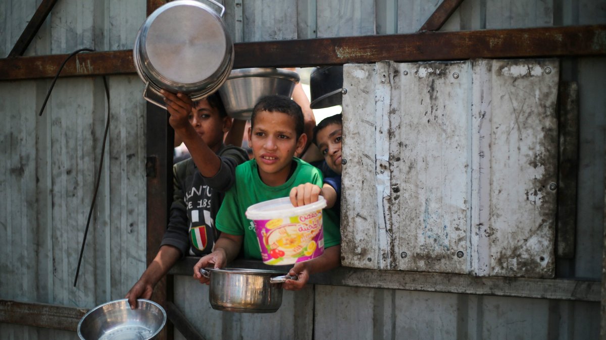 Palestinian children reach out with their pots as they wait for food at a distribution point in Nuseirat, central Gaza Strip, Palestine, June 2, 2025. (AFP Photo)