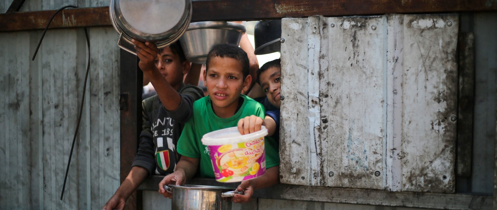 Palestinian children reach out with their pots as they wait for food at a distribution point in Nuseirat, central Gaza Strip, Palestine, June 2, 2025. (AFP Photo)