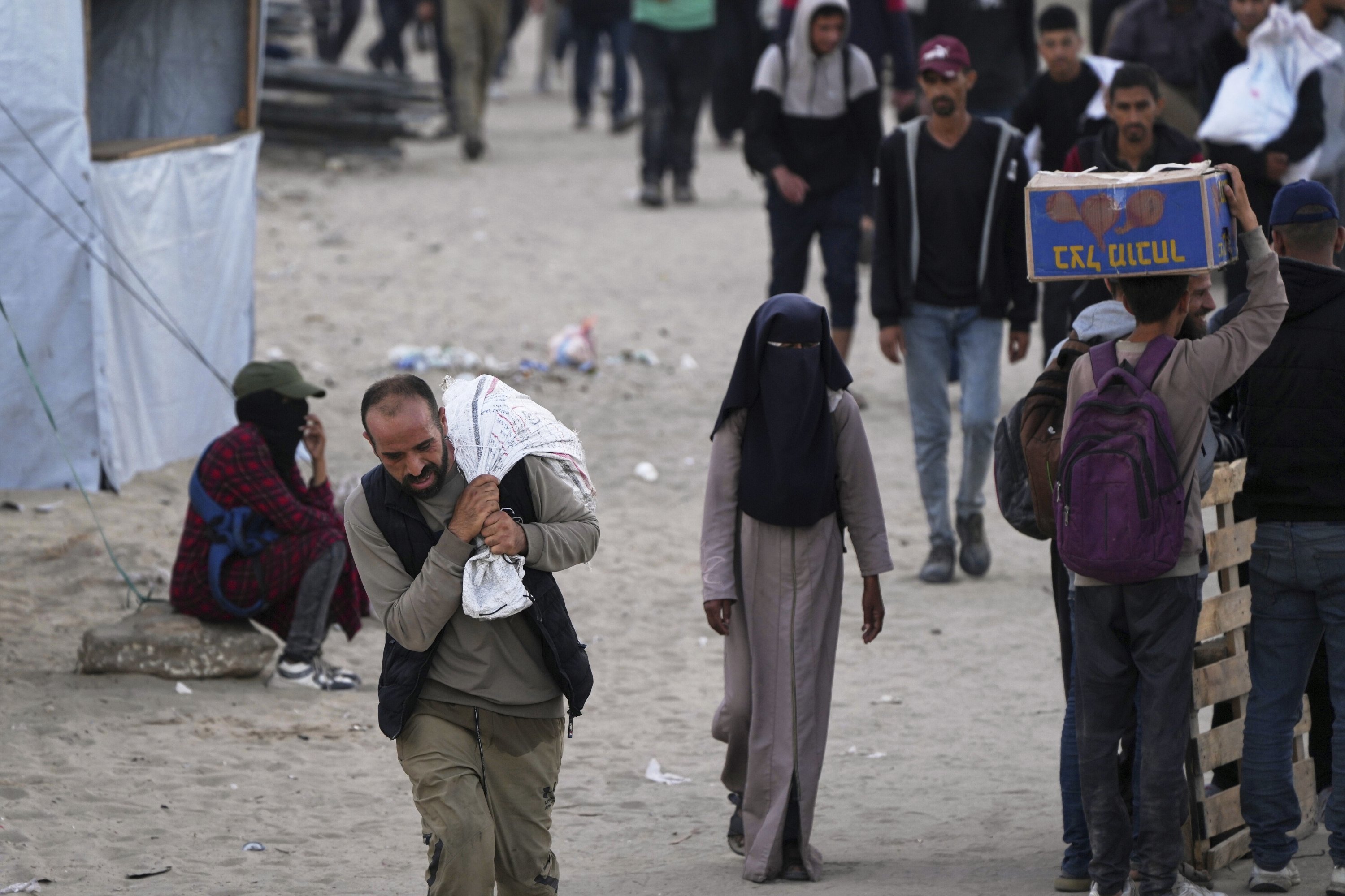 People carry bags filled with food and humanitarian aid provided by the Gaza Humanitarian Foundation, Khan Younis, Gaza Strip, Palestine, June 3, 2025. (AP Photo)