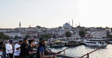 People fish on Galata Bridge backdropped by Süleymaniye Mosque during sunset, Istanbul, Türkiye, May 28, 2025. (EPA Photo)