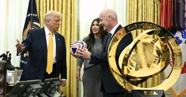 (L-R) President Donald Trump, Homeland Security Secretary Kristi Noem and FIFA President Gianni Infantino look at the new FIFA Club World Cup trophy and official ball in the Oval Office of the White House, Washington, U.S., March 7, 2025. (AP Photo)