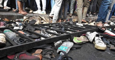 People walk past shoes left behind following a stampede outside a cricket stadium in Bengaluru, India, June 4, 2025. (Reuters Photo)