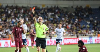 Referee Yiğit Arslan shows the red card to Fenerbahçe&#039;s Mert Müldür during the Süper Lig match between Fenerbahçe and Hatayspor at the Mersin Stadium, Mersin, Türkiye, May 26, 2025. (AA Photo)