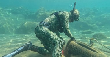 Divers remove waste from the sea floor during a cleanup event at Yahşi Beach, Muğla, Türkiye, June 5, 2025. (AA Photo)