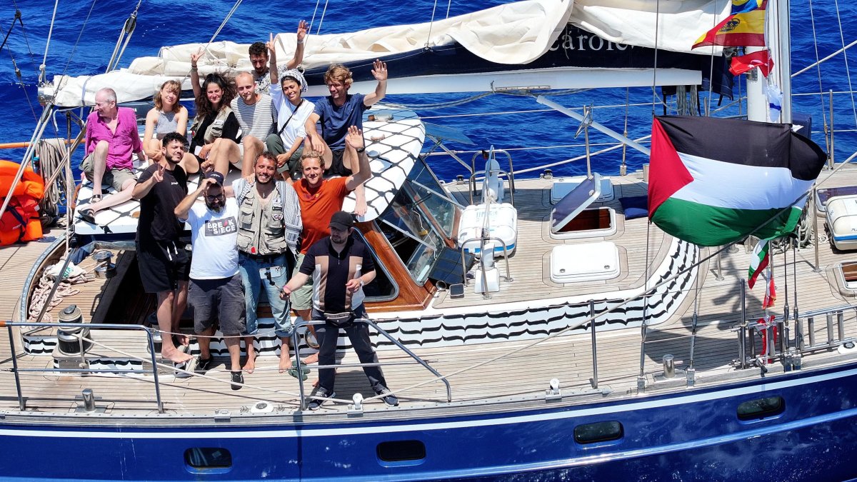 Pro-Palestine activists onboard the Madleen wave at the camera near Sicily, Italy, June 6, 2025. (AA Photo)